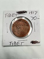 Obverse of 1917 Tibet copper coin inside 2x2 holder