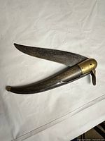 Knife fully open displaying curved blade and handle