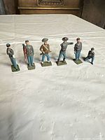 Six Britains lead toy soldiers lined up on table