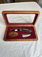 Knife in wooden glass-top display case, full view