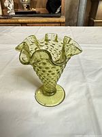 Side view showing hobnail texture, footed base, olive green colour