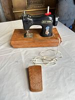 Front view of Holly Hobbie toy sewing machine on base with attached foot pedal