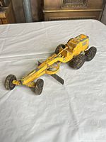 Full side view of yellow Hubley road grader showing overall form and wear