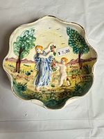 Top view of scalloped ceramic bowl showing hand-painted relief scene