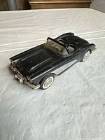 Top and side view of black die-cast Corvette-style toy car showing overall design and condition