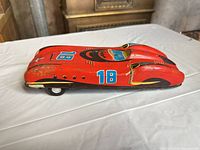 Side view of red Linemar tin race car showing number 18 graphics and driver