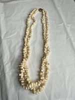 Full view of necklace showing three strands of ivory coral chips