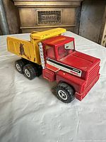 Left front angled view showing cab, dump bed, wheels and overall wear