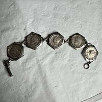 Front view of entire bracelet showing five coin links and clasp
