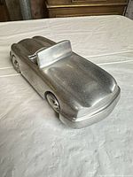 angled front view of silver cast metal convertible car