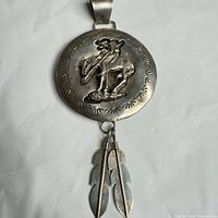 Front view showing full pendant with feathers and bail