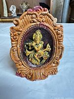 Front view showing deity relief, paint details and ornate border