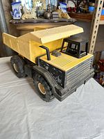Front three-quarter view of Tonka dump truck showing cab, grille, wheels and tilting bed