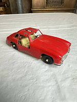 Side view of red die-cast Mercedes-Benz 300 SL showing body, interior and wheels