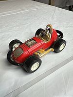 Overall view of red Tootsietoy race car showing body, wheels, engine detail