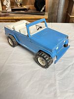 Front three-quarter view showing blue body, tires, bumper