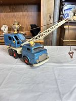 Full view of blue tin wind-up crane truck with boom extended