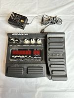 Full view of Zoom GFX-707 effects unit with power adapter