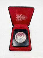 Open clamshell case displaying 1974 Winnipeg silver dollar in plastic holder, red interior lining visible