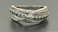 Front view of sterling silver bypass ring with blue gemstones