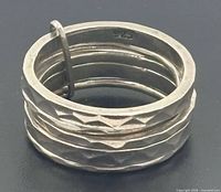 Stacked silver rings showing 925 stamp and hammered texture