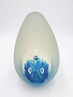 front view of frosted glass paperweight showing internal blue design and bubble