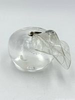 front view of clear glass apple paperweight displaying leaf and stem