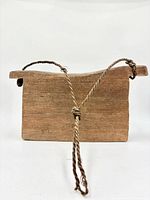 Front view showing rectangular wooden body and rope hanger