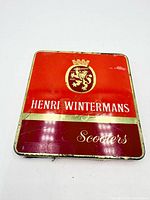 Closed tin front view showing crest and branding