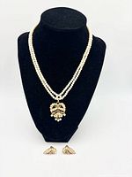 Necklace on display bust with earrings in front