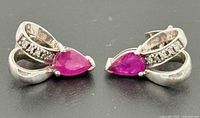Front view showing both earrings, rubies and accent stones