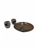 Two small cups and matching plate showing full set