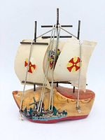 Front view showing painted clog hull, sails with crests, rigging