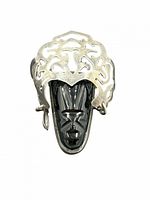 Front view of brooch showing carved onyx mask and silver headdress