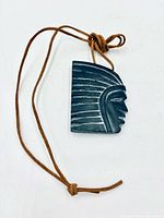 Front view of carved stone pendant on cord