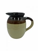 Full view of two-tone stoneware pitcher showing colors and handle
