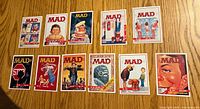 Fronts of 11 Topps Mad Magazine trading cards spread on table