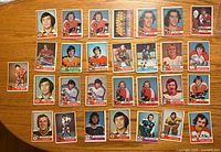 Front view of 29 1974-75 O-Pee-Chee hockey cards laid out on a wooden surface
