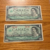 Front view of both 1967 Canada $1 bills showing portrait and text
