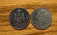Reverse of both 1973 Canadian 50-cent coins showing coat of arms