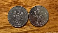 Both 1984 Canadian 50-cent coins reverse showing Coat of Arms legend and dates
