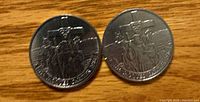 Reverse sides of both 1984 Jacques Cartier coins showing explorer design