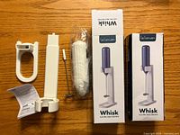 Two boxed La Lavan electric milk frothers with unpacked components visible including handles, whisk heads, covers and instructions