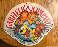 Front view of die-cut Garfield & Company cardboard sign on table