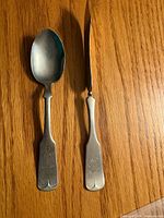 Front view of both spoons displaying bowls and monogrammed handles