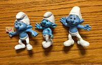 Front view of three Smurf figurines