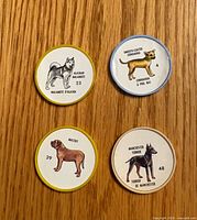 Front view of four dog breed coins showing illustrations and numbers