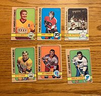 Fronts of six 1972-73 O-Pee-Chee hockey cards displayed on wood surface