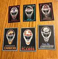 Front view of six NHL goalie mask cards/stickers showing team graphics