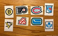 Front view of eight NHL emblem cards displaying team logos